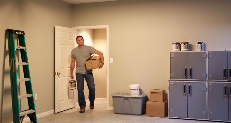 Man carrying a box walking into his garage
