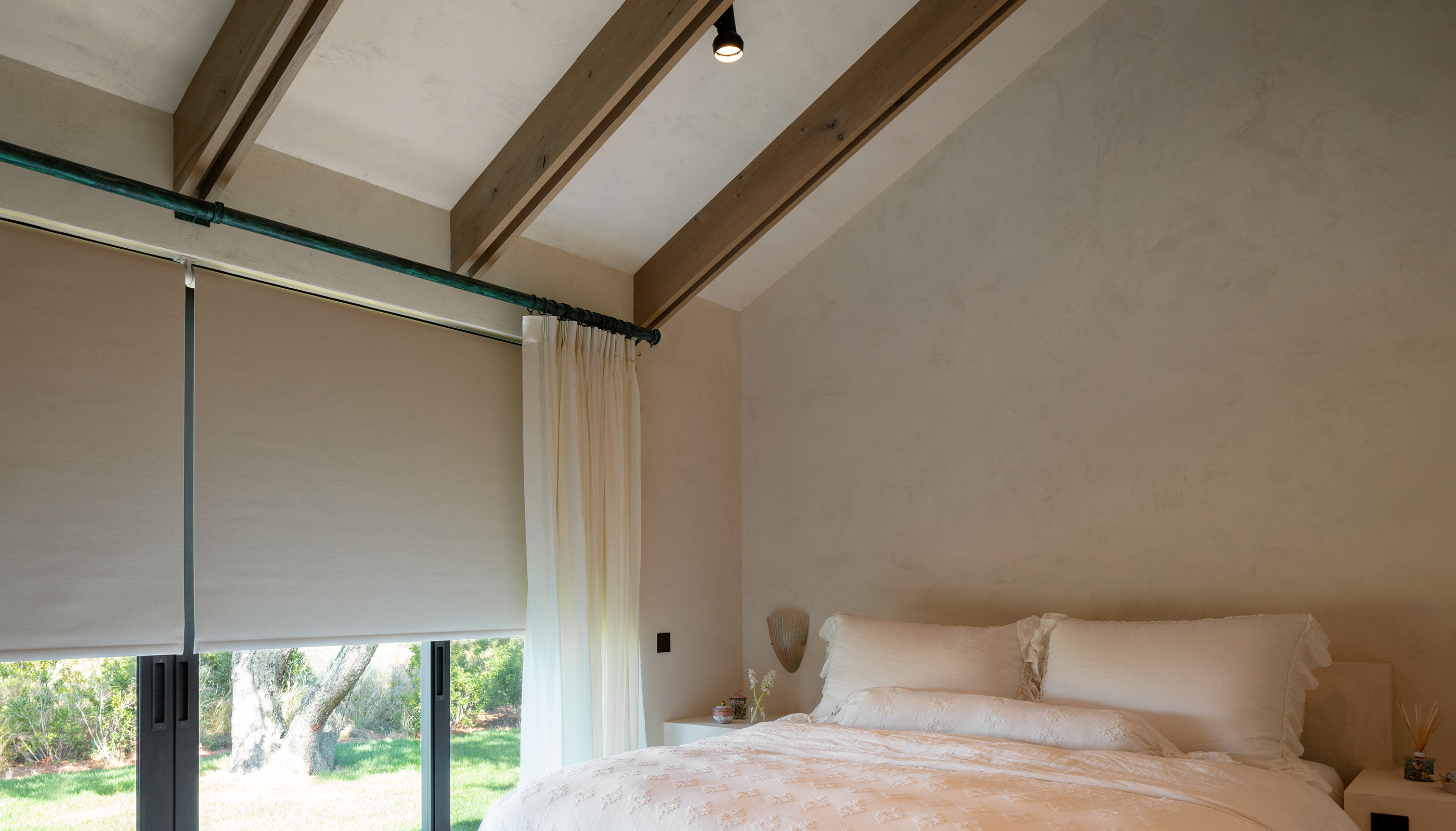An East Hampton residential bedroom with Lutron Ketra lamps, Palladiom roller shades, and Alisse keypads.. © Magda Biernat Photography