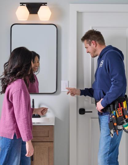 A Pro is showing a client how to use their new Caseta products.