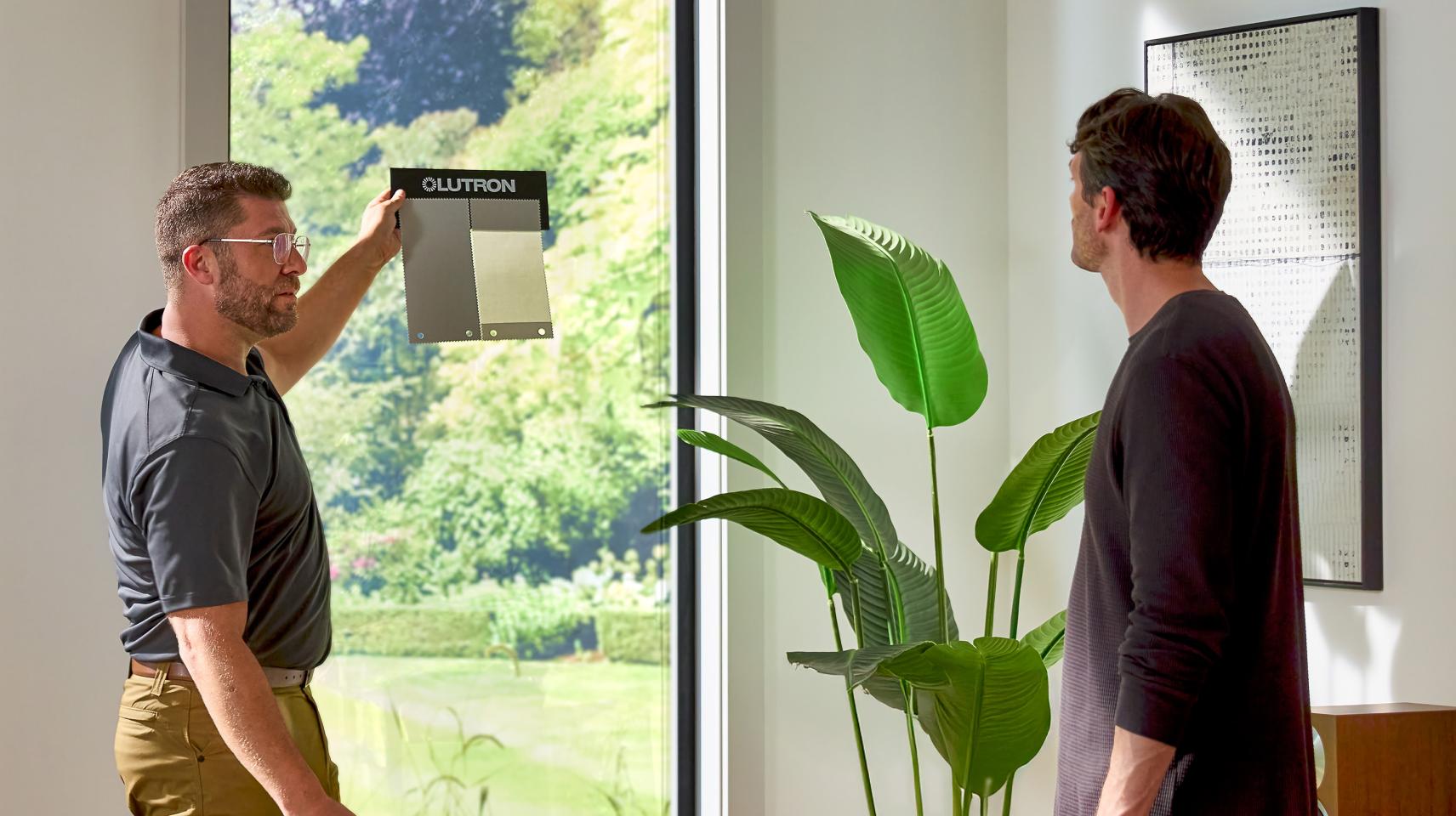 Lutron professional installer demonstrating Roman shade consultation with 24/7 support