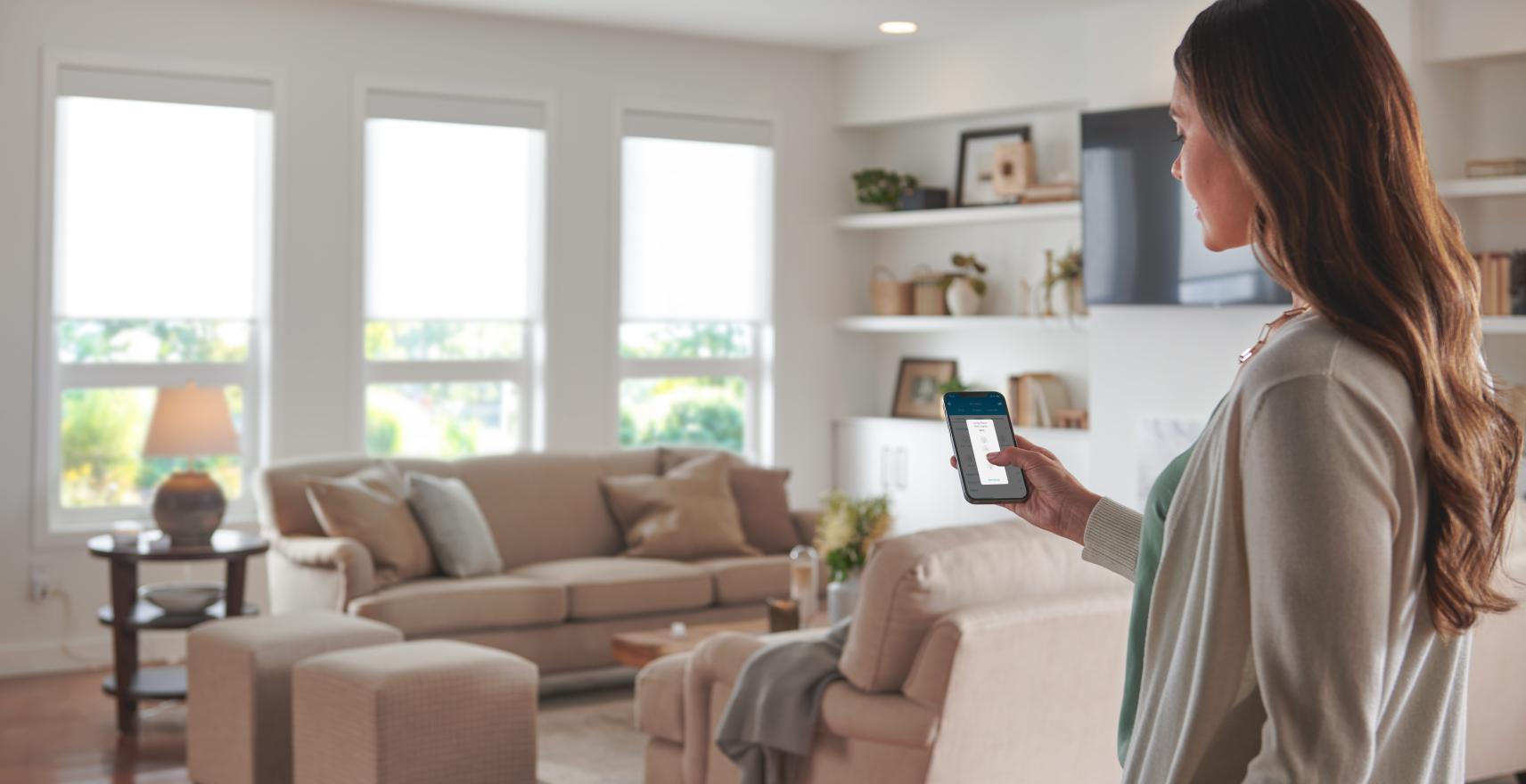 A homeowner is controlling her smart products through the Lutron mobile app.
