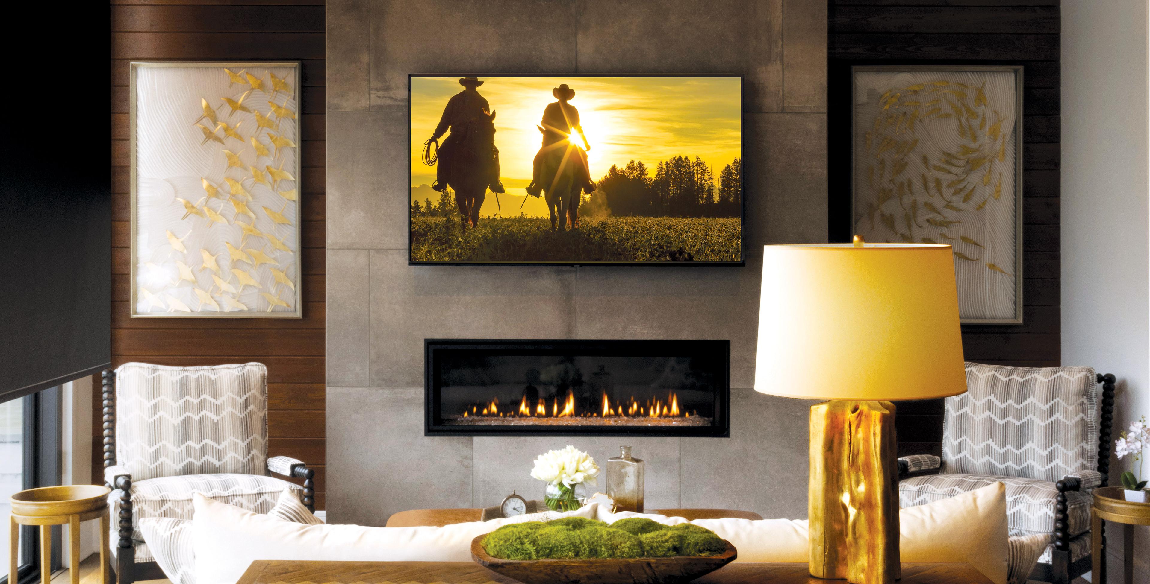 Well-appointed, lamplit family room with lit fireplace and Western movie playing on a screen.