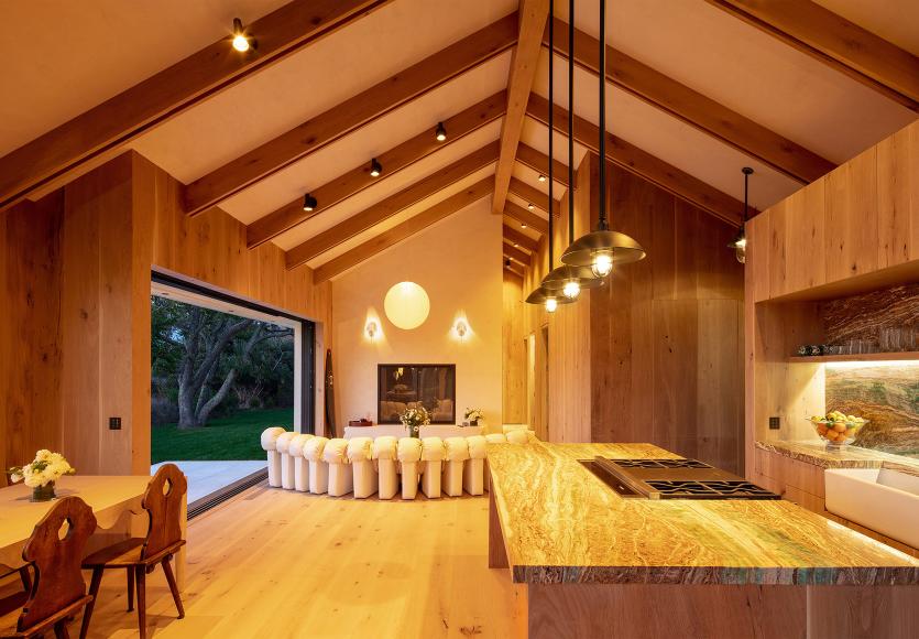 Open kitchen and living space with warm evening lighting, showing how lighting scenes shift with time of day.