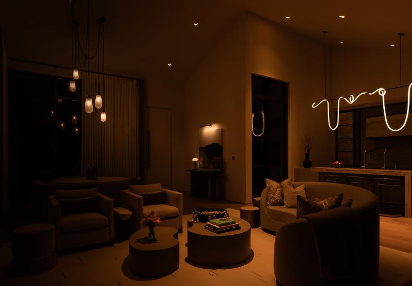 Living room dimly lit for a movie night atmosphere with warm, low lighting.