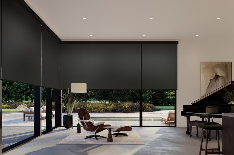 Living room with floor-to-ceiling windows fitted with translucent roller shades that soften daylight while allowing outdoor views.