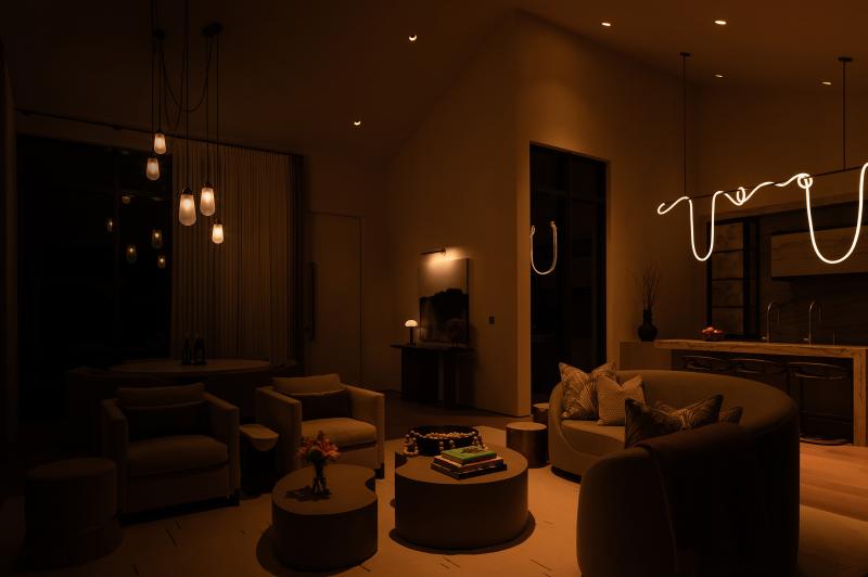 Living room dimly lit for a movie night atmosphere with warm, low lighting.