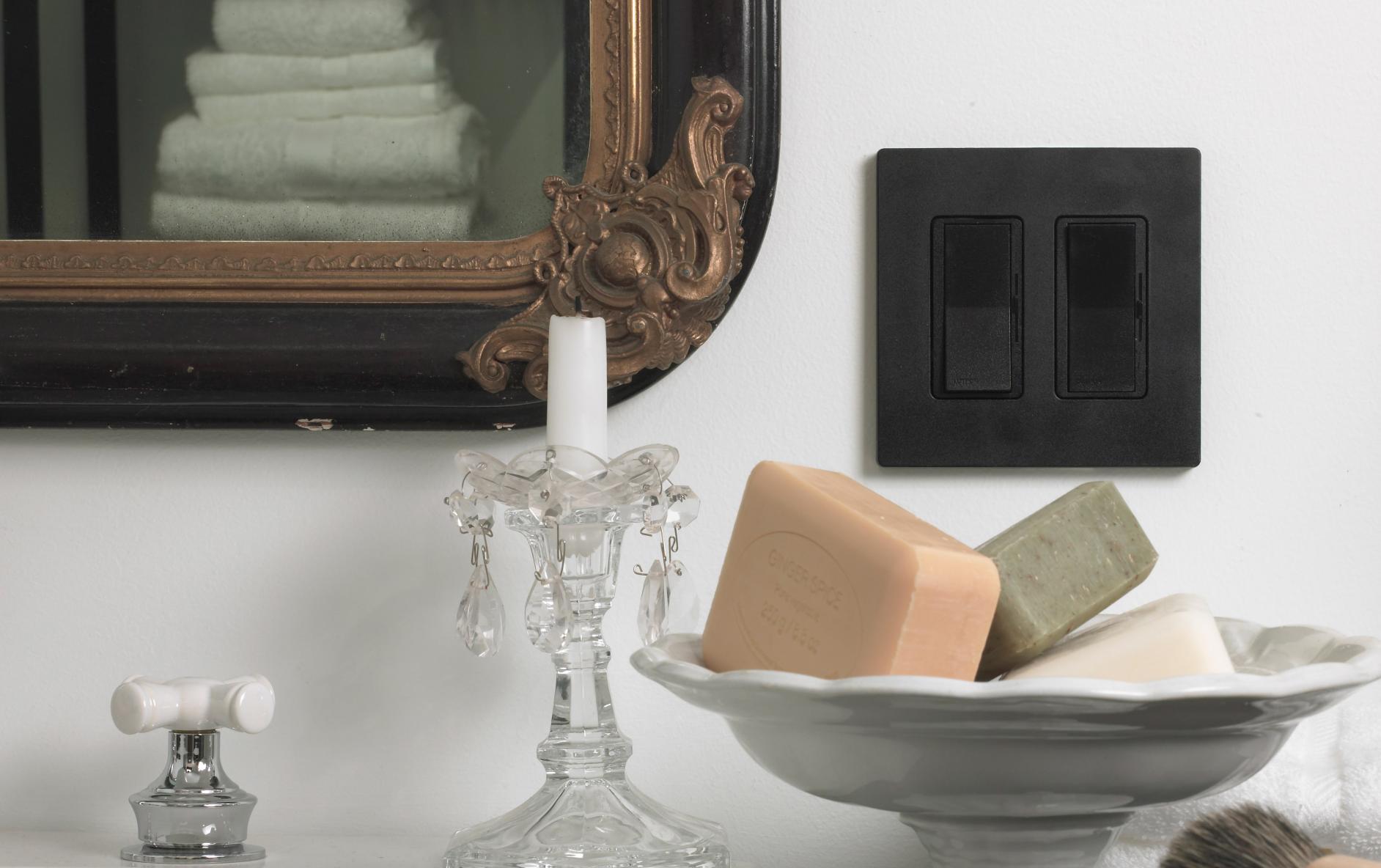 A sleek, black dimmer switch in a bathroom setting.