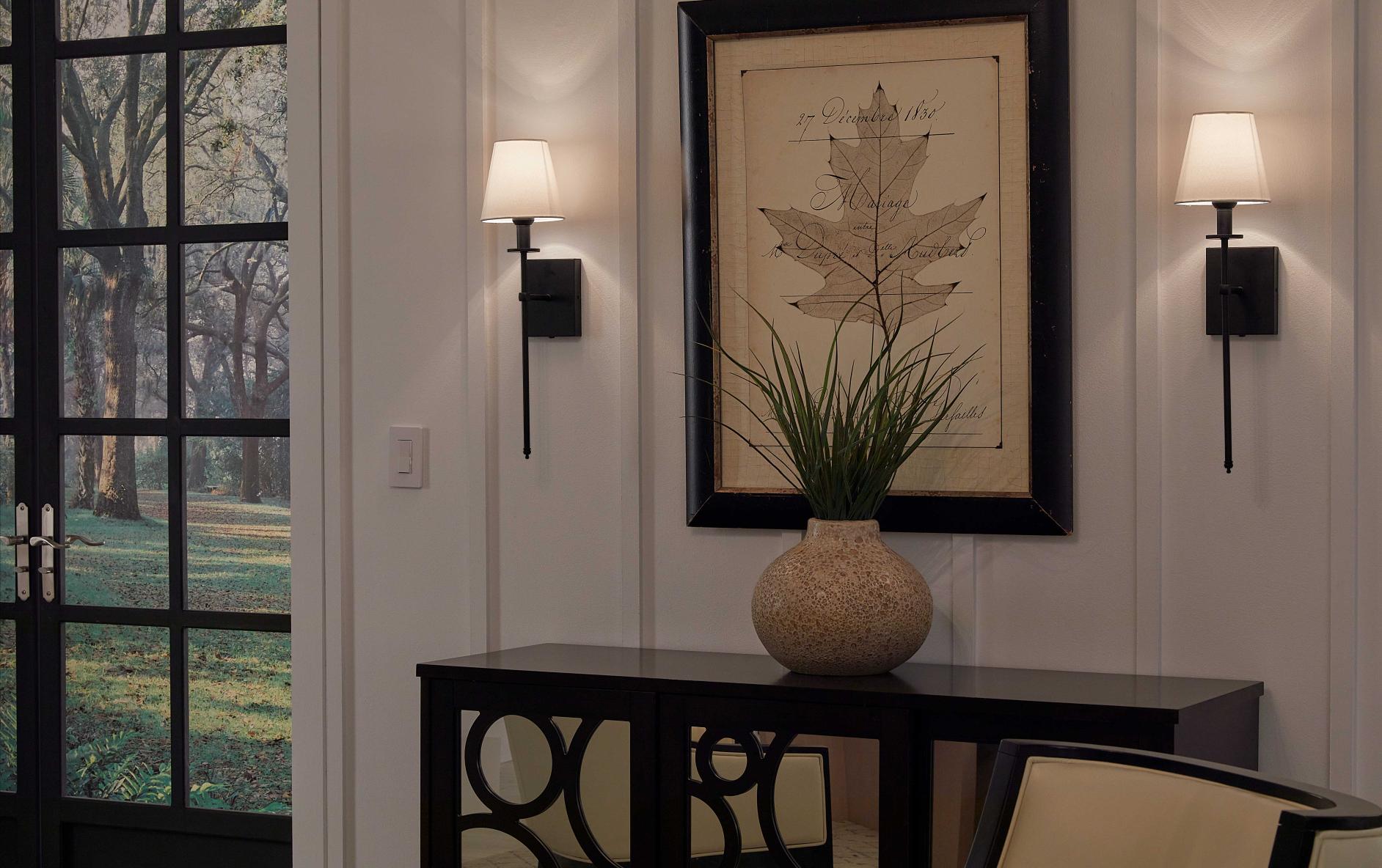 Two wall sconces in a living room dimmed to a low, ambient level.