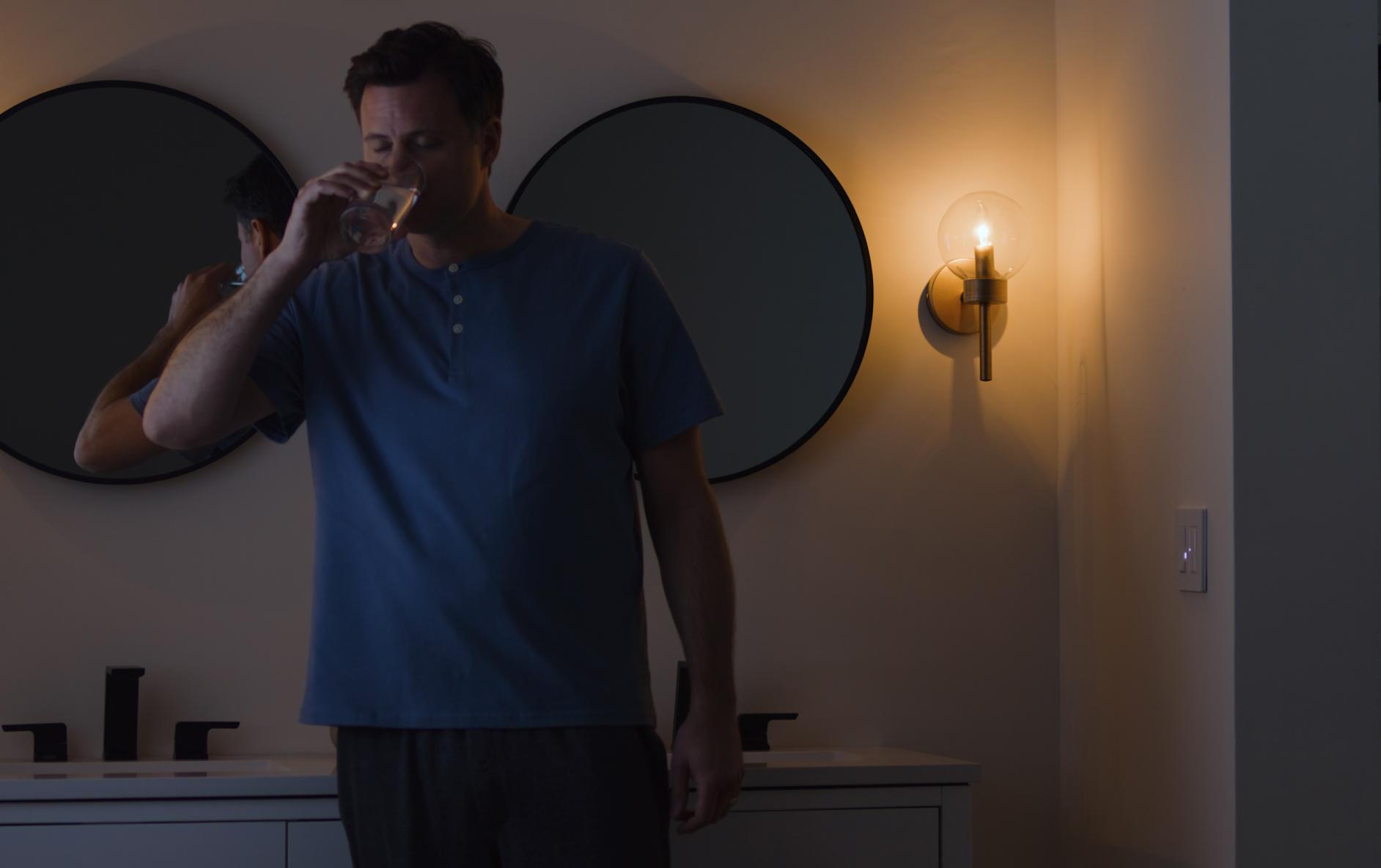 The Diva dimmer with Night Mode casts a low light while a man gets a drink at night.
