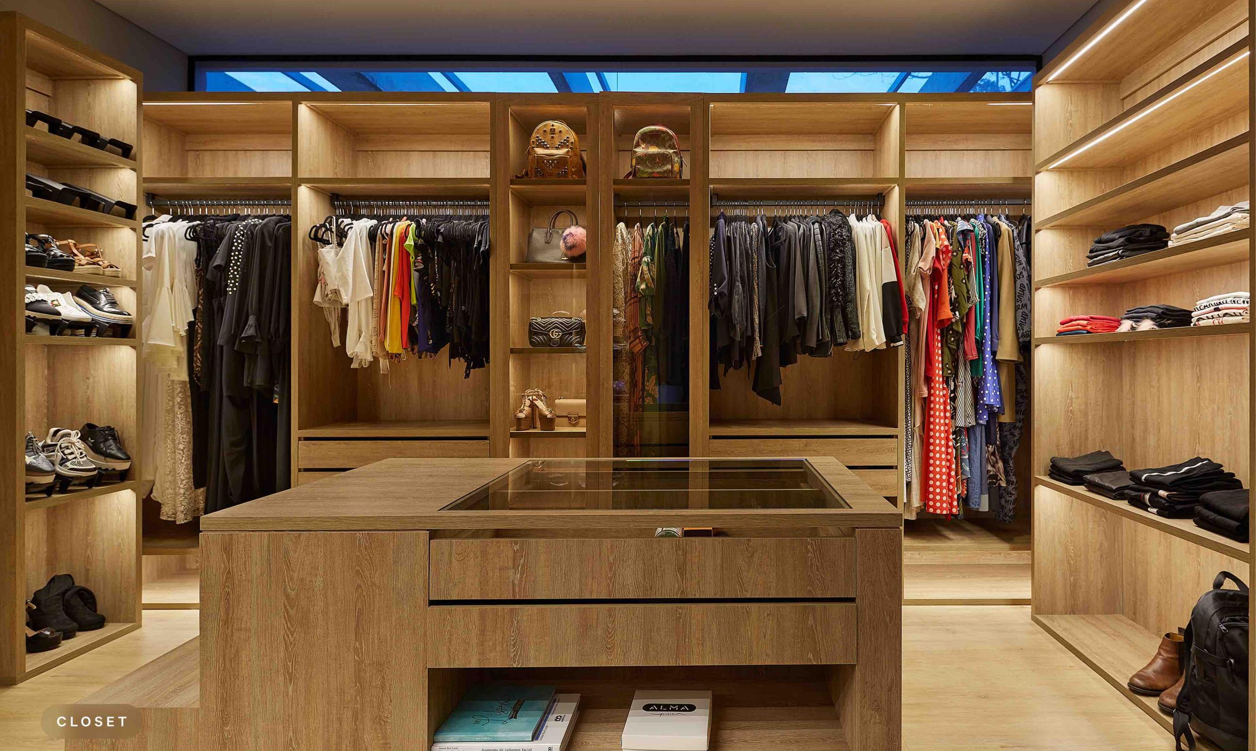 Walk-in closet with layered lighting that enhances visibility across shelves, hanging storage, and display areas.